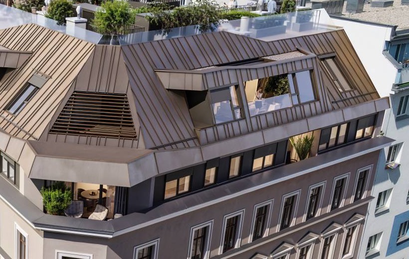 Bronzefarbenes Dach mit Gaupen und Eckterrasse des Penthouse