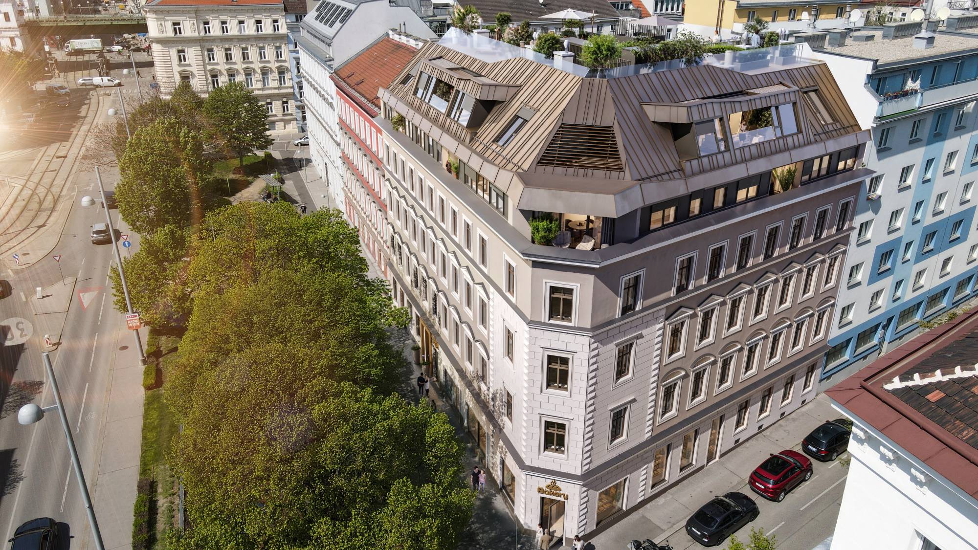 Luftaufnahme des Eckhauses Zimmermannplatz 6 mit neuem, bronzefarbenem Dachgeschoss, Dachterrassen und Baumreihe am Platz
